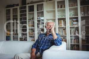 Worried senior man sitting on sofa