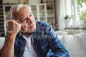 Worried senior man sitting on a sofa