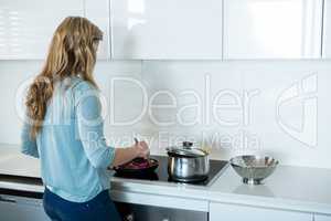 Woman cooking food in kitchen