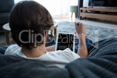 Man using digital tablet in living room