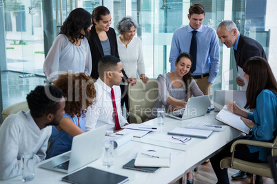 Group of businesspeople discussing over laptop