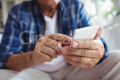 Mid-section of senior man using mobile phone