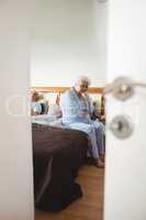 Worried senior woman sitting on bed