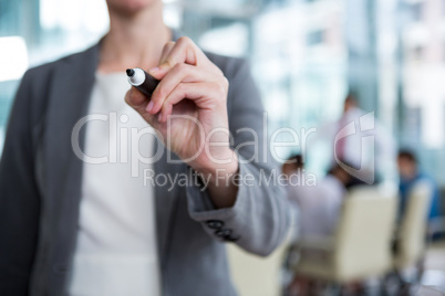 Businesswoman writing with marker on glass