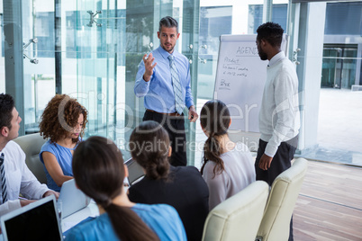 Businessman discussing on white board with coworkers