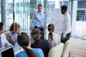 Businessman discussing on white board with coworkers