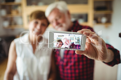 Senior couple clicking a picture on mobile phone