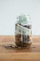 Close-up of coins and currency notes in jar