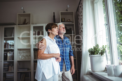 Senior couple looking through window