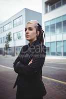 Thoughtful businesswoman standing with arms crossed