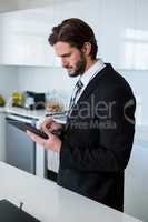 Businessman using digital tablet in kitchen