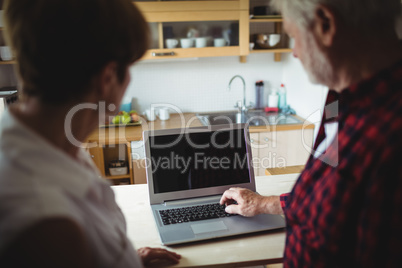 Senior couple using laptop