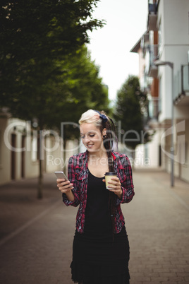 Woman using mobile phone while walking on street