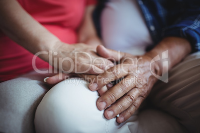 Mid-section of senior couple holding hands