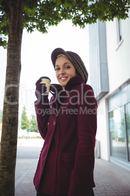 Woman smiling and holding a cup of coffee