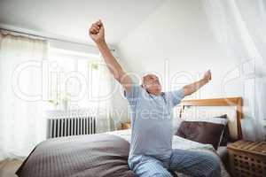 Senior man yawning on bed