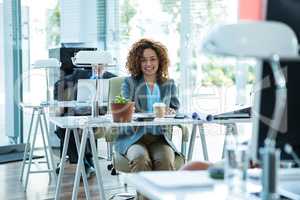 Smiling businesswoman sitting on chair in office