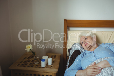 Worried senior woman relaxing on bed