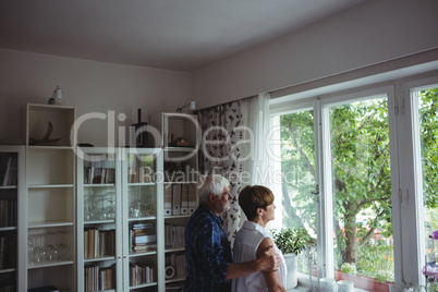 Senior couple looking through window