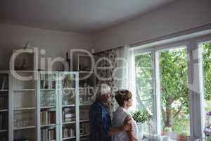 Senior couple looking through window