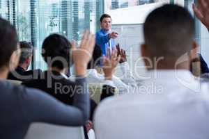 Colleagues raising their hands during meeting