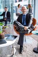 Smiling businessman sitting on chair in office