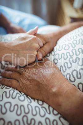 Nurse holding hands of senior woman