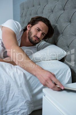 Man waking up with mobile alarm clock