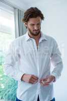 Man wearing a white shirt in bedroom