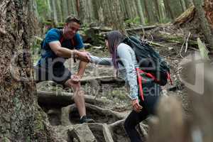 Hiking woman get help from a smiling man