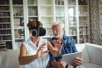 Senior couple using digital tablet and virtual reality headset
