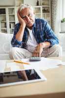 Worried senior man sitting on a sofa