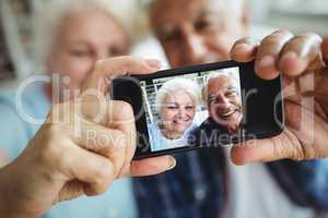 Senior couple taking a photo from mobile phone