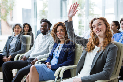 Businesswoman raising hand during meeting