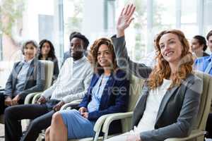 Businesswoman raising hand during meeting