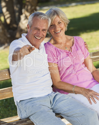 Happy Senior Couple Sitting on Bench in Sunshine