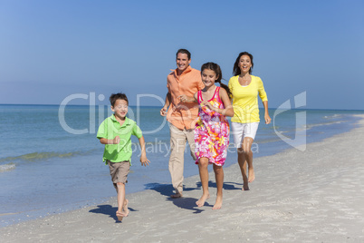 Mother, Father and Children Family Running Having Fun At Beach