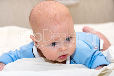 Indoor close up shot of boy lying on stomach