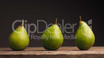 Three organic pears on wood