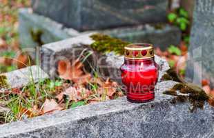 One lonely votive candle on tombstone
