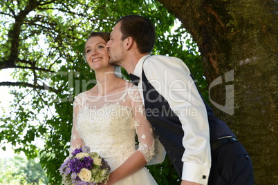 Glückliches junges Brautpaar, Bräutigam küsst die Braut