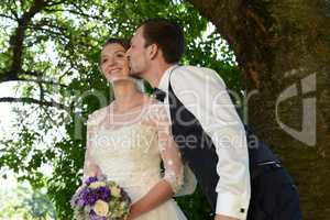 Glückliches junges Brautpaar, Bräutigam küsst die Braut