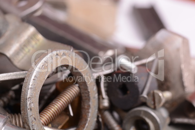 Big stack of metal threaded screwbolts nuts and bolt washers on metallic background construction concept.