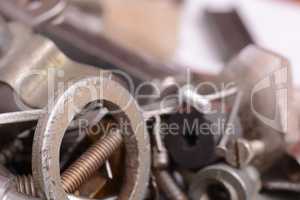 Big stack of metal threaded screwbolts nuts and bolt washers on metallic background construction concept.
