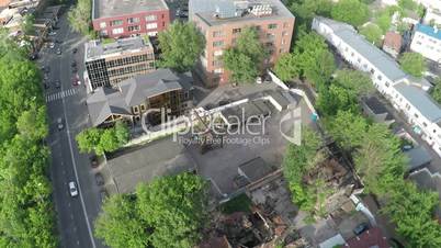 Aerial shot of street with car traffic and ruined house