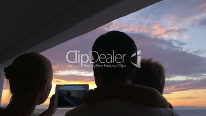 At sunset family photographed on tablet in city Perea, Greece