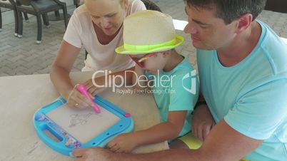 Father and son watch mother is painting pet on magnet board