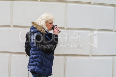 Frau mit einem Kaffee to go.