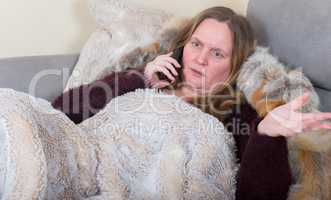 Frau ist krank und telefoniert mit Handy