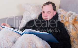 Mann ist krank und liest ein Buch